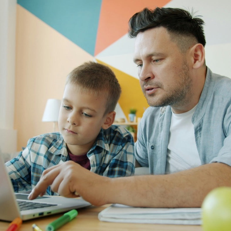 A parent and child working through a math lesson together at a laptop